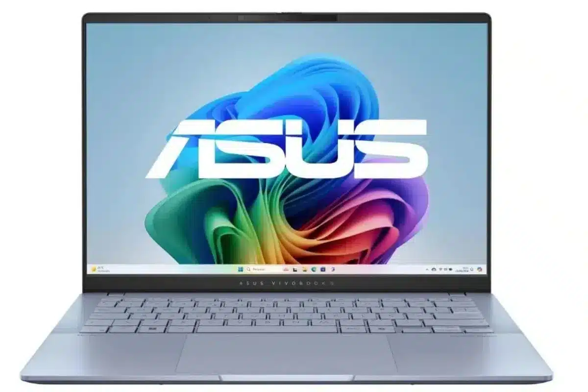 ASUS Vivobook S14 aberto, visto de frente, com acabamento prateado, tela exibindo imagem colorida do Windows e destaque para o recurso Copilot+ PC.