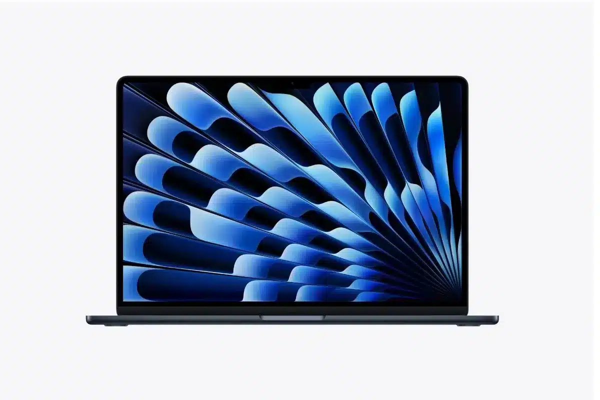MacBook Air M5 aberto, visto de frente, com acabamento escuro e tela exibindo um padrão abstrato em tons de azul e preto.