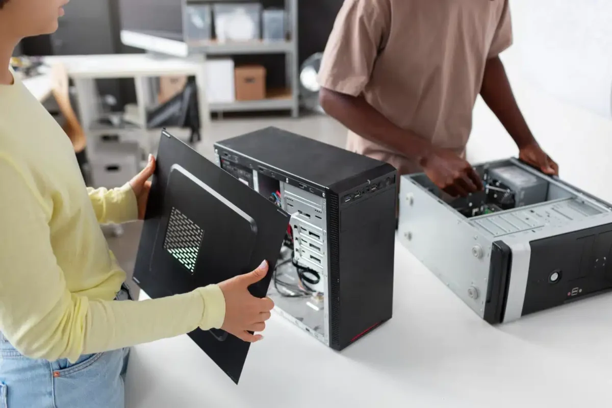 Pessoas realizando manutenção em computadores desktop para ampliar a vida útil de equipamentos de TI.